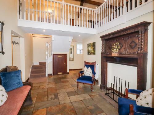 a living room with a fireplace and blue chairs at Meadow Place in Ipstones