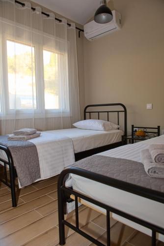 a bedroom with two beds and a window at Lila's villa maisonette with private pool in Nerotriviá