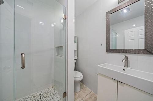 y baño con aseo, lavabo y espejo. en Capri Inn & Apartments, en Lake Worth