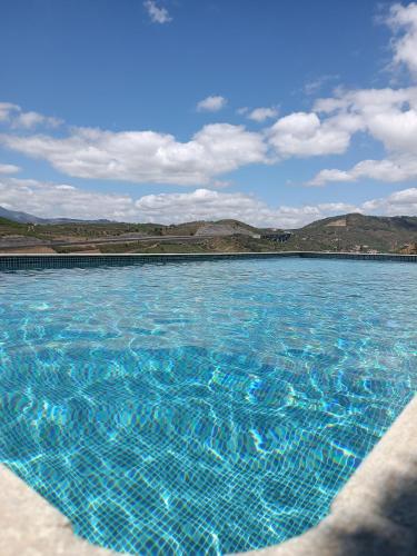 a large swimming pool with blue water at Casa do Romezal in Peso da Régua