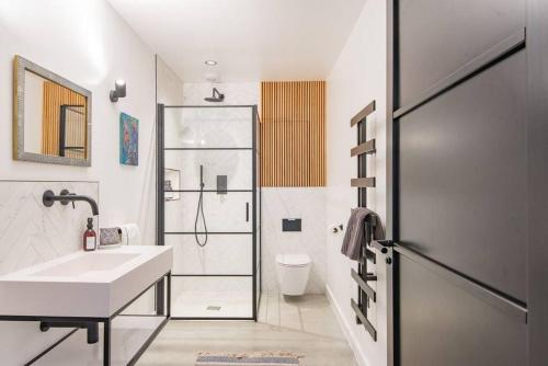 a white bathroom with a sink and a shower at The Barn in Sandwich