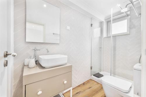 a white bathroom with a sink and a toilet at RG Casa do Carmo in Faro