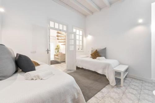 Habitación blanca con 2 camas y mesa en RG Casa do Carmo, en Faro