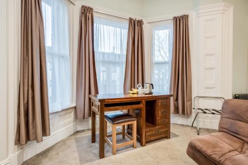an office with a desk and a chair and windows at Central Belfast Apartments Harpers in Belfast