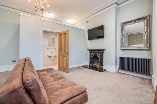 a living room with a couch and a fireplace at Central Belfast Apartments Harpers in Belfast