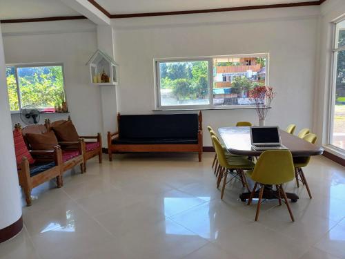 ein Wohnzimmer mit einem Tisch, Stühlen und einem Sofa in der Unterkunft Seven Waves Beachfront Vacation Home, Bauang La Union 