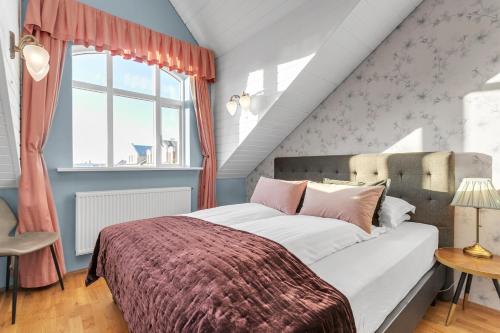 - une chambre avec un grand lit et une fenêtre dans l'établissement Gerður Apartments, à Reykjavik