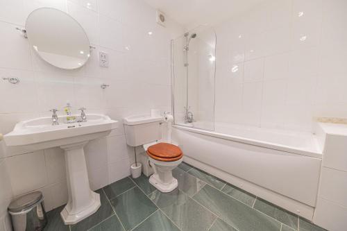 a bathroom with a toilet and a sink and a tub at Stables Cottage Far Sawrey Windermere in Far Sawrey