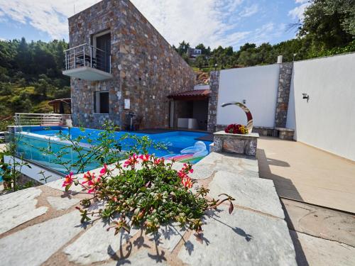 eine Villa mit einem Pool und einem Haus in der Unterkunft Sky Sea Resort & Villas in Skiathos-Stadt
