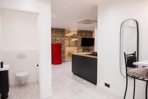 W łazience znajduje się lustro i czerwona lodówka. w obiekcie " Art Loft d'Exception " au Cœur de Cannes - 90m de Design et de Confort w Cannes