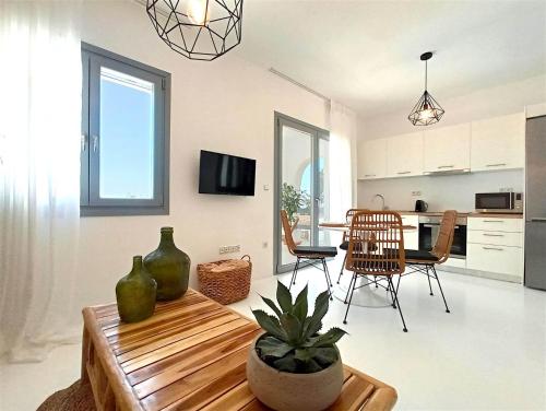 a kitchen and living room with a table and chairs at The Nine Graces - Kastraki Villas with Private Swimming Pool in Kastraki Naxou