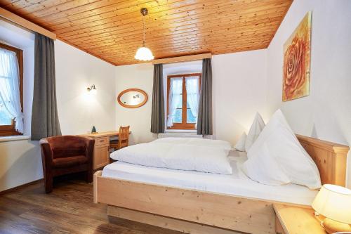um quarto com uma cama, uma secretária e uma cadeira em Haus Benzmühle em Reit im Winkl