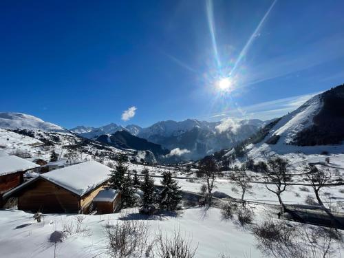 a snow covered mountain with the sun in the sky at Charmant Studio 4P Alpe d'huez in LʼHuez