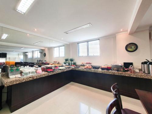 a bar in a restaurant with a counter top at Avenida Palace Hotel in Joinville
