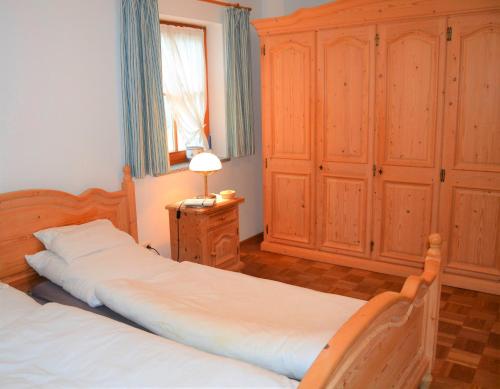 2 camas en un dormitorio con armarios de madera en Ferienwohnung Am Anger, en Samerberg