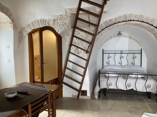 Un dormitorio con una cama y una escalera en una habitación en Trulli Antichi Mestieri - Widespread Trulli in the historic center, en Alberobello