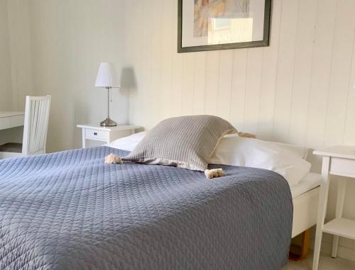 a bed with a blue comforter in a bedroom at Helgas Hus tre rum o kök in Hunnebostrand