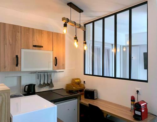 a kitchen with a counter top with a window at T1 bis cosy et spacieux - wifi - parking gratuit in Angers