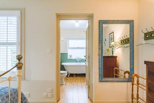 a bathroom with a tub and a sink and a mirror at Star Cottage in Whitstable