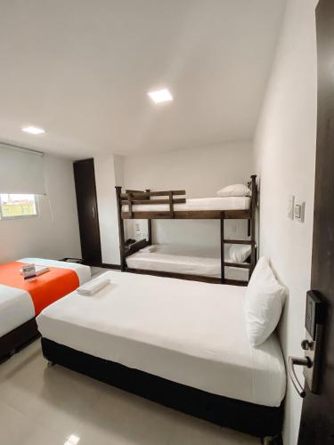 a bedroom with two bunk beds and a couch at Hotel G Cartagena in Cartagena de Indias