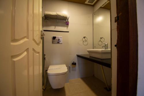a bathroom with a toilet and a sink at Kodai Resort Hotel, Kodaikanal in Kodaikānāl