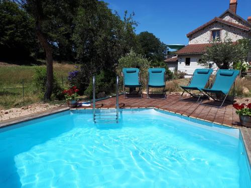 two chairs and a swimming pool in a yard at La Perle Secrète in Theneuille
