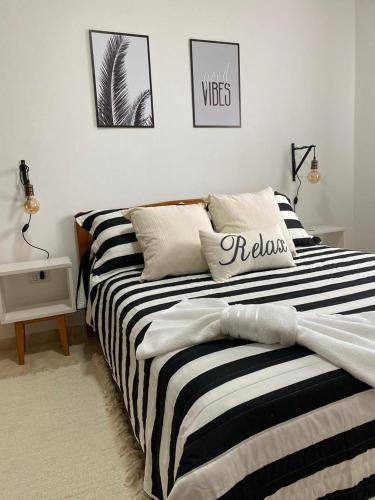 1 dormitorio con cama de rayas en blanco y negro en Complejo Armonia y Paz en Federación
