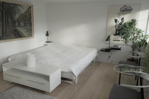 コペンハーゲンにあるApartmentInCopenhagen Apartment 1244の白いベッドルーム(ベッド1台、テーブル付)