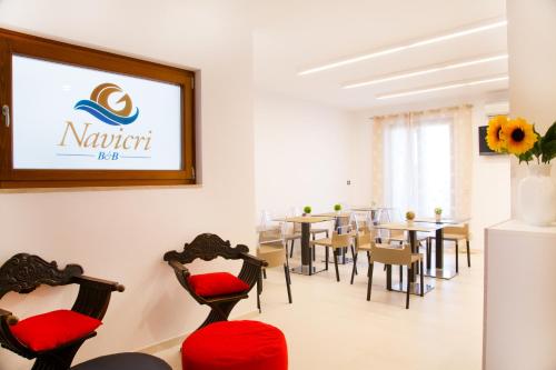 a dining room with tables and chairs and a screen at Navicri B&B in Vieste