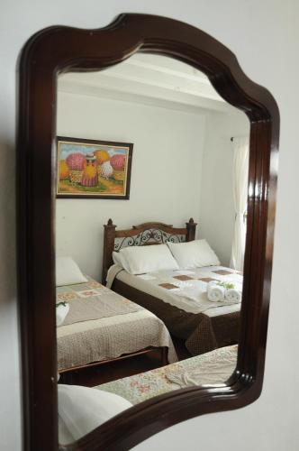 a mirror reflection of a bedroom with two beds at Hospedaje La Casona in Tabio