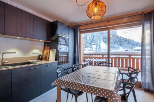 une cuisine et une salle à manger avec une table et des chaises dans l'établissement Maika B103, à Morzine