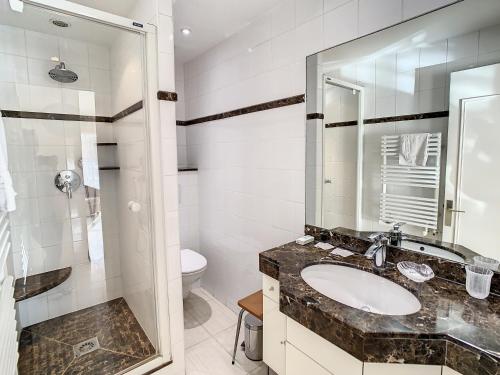une salle de bain avec un lavabo, des toilettes et un miroir dans l'établissement Studio luxueux et spacieux avec terrasse, à Cannes