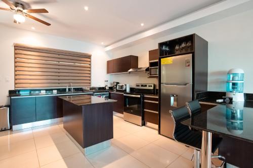 a kitchen with black cabinets and a black counter top at CasaGuana in Playa Hermosa
