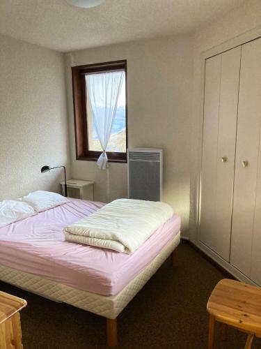 1 dormitorio con 1 cama con ventana y vestidor en Appartement de 2 chambres avec balcon amenage a Les Orres a 2 km des pistes en Les Orres