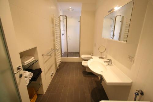 a white bathroom with two toilets and a sink at Cernobbio 2 Bedroom Apartment in Cernobbio