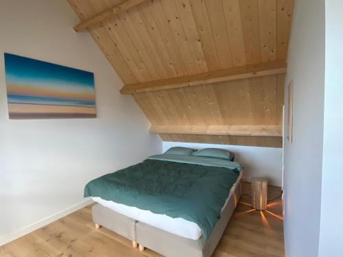 a bed in a room with a wooden ceiling at De Porrel Polsbroek Unit met Privé Jacuzzi, Spa en Sauna in Polsbroek