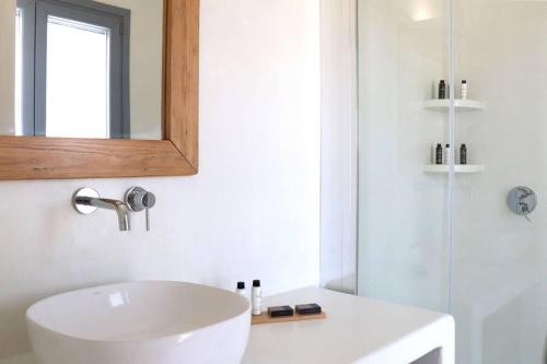 a bathroom with a white sink and a mirror at The Nine Graces - Kastraki Villas with Private Swimming Pool in Kastraki Naxou
