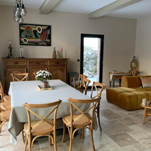 un salon avec une table, des chaises et un canapé dans l'établissement La Grange des Loges, à Boucé