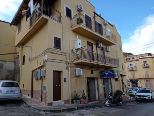 a yellow building with cars parked in front of it at Nonna Sicula in Agrigento