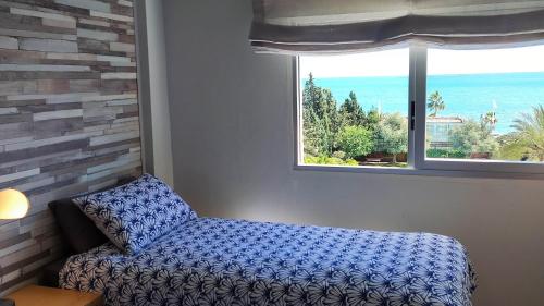ein Schlafzimmer mit einem blauen Bett und einem Fenster in der Unterkunft Appartement Jumate te Altea-Albir in Altea