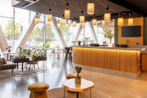 a restaurant with a bar and tables and chairs at Best Western M-Treize Paris Asnieres in Asnières-sur-Seine