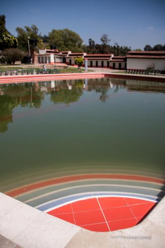 a large pond with a rainbow in the water at Hospedaje La Casona in Tabio