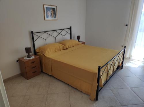 ein Schlafzimmer mit einem Bett, einer Holzkommode und einem Bett sidx sidx sidx in der Unterkunft Casa Vacanze Riccio di Mare in Santa Maria di Leuca