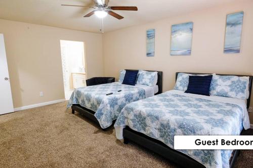 a bedroom with two beds and a ceiling fan at Stunning Family Home in North Houston!!! - Briar Creek in Spring