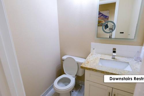 a bathroom with a toilet and a sink and a mirror at Stunning Family Home in North Houston!!! - Briar Creek in Spring
