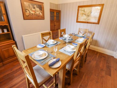 a dining room with a wooden table and chairs at Coastguard Cottages in Hull