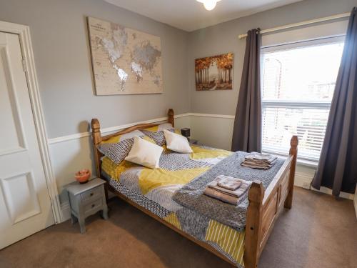 een slaapkamer met een bed en een raam bij Coastguard Cottages in Hull