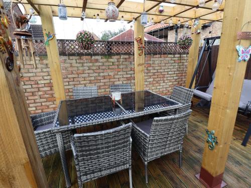 a table and chairs under a pergola on a patio at Coastguard Cottages in Hull
