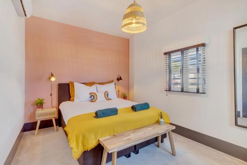 a bedroom with a bed with a yellow blanket at New & luxurious Two Bedroom Apartment at the Water in Kralendijk
