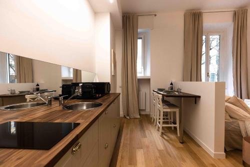 uma cozinha com dois lavatórios e uma cama num quarto em Divini Gae Aulenti em Milão